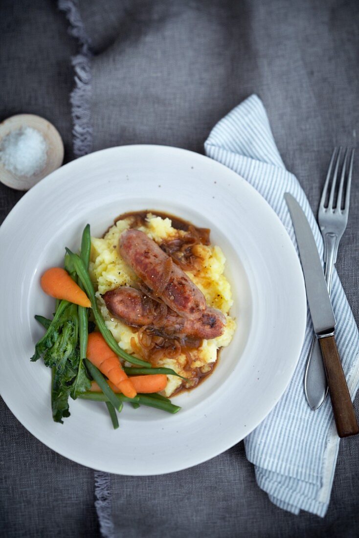 Bratwürste mit Zwiebeln auf Kartoffelpüree