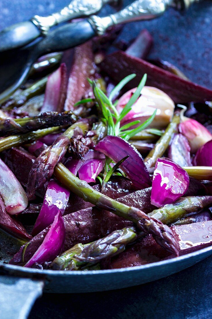 Purple carrot salad with green asparagus, rosemary and red onions