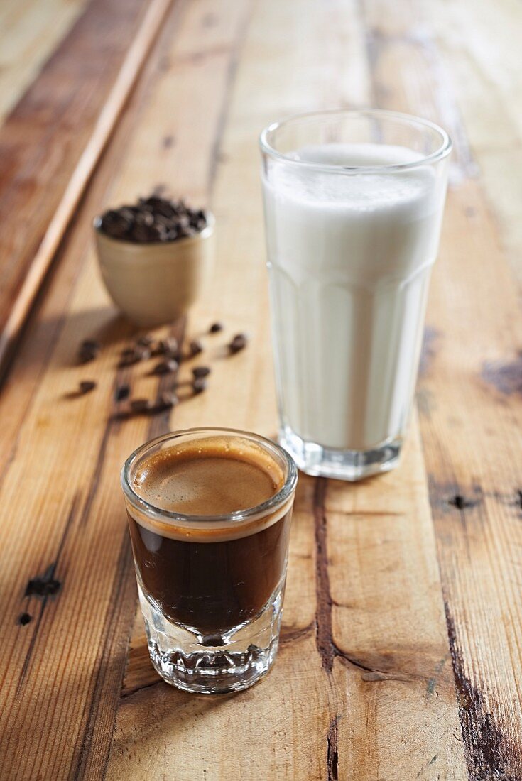 A glass of espresso and a glass of hot milk