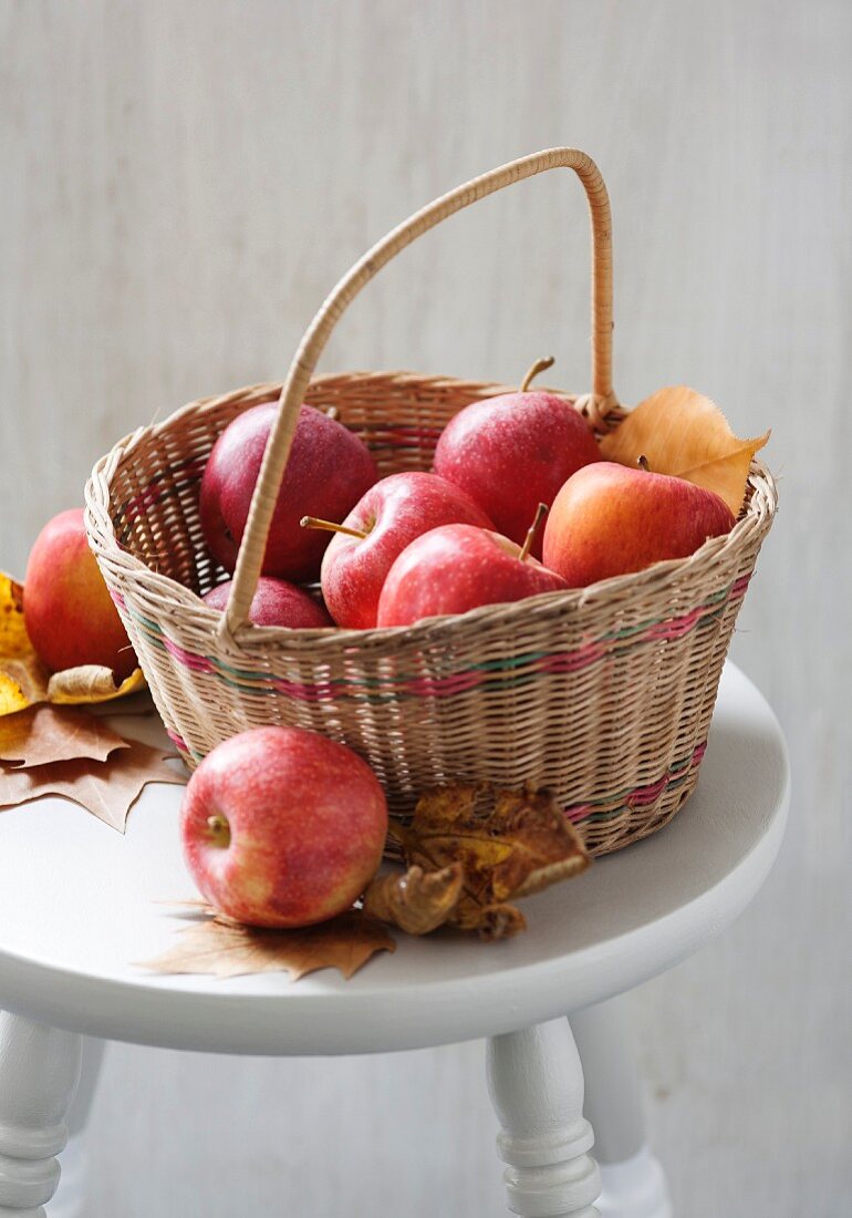 Äpfel im Korb mit Herbstlaub