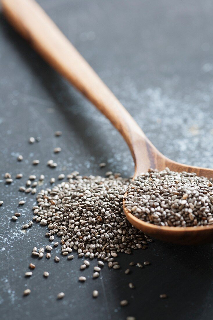 Black chia seeds on a wooden spoon
