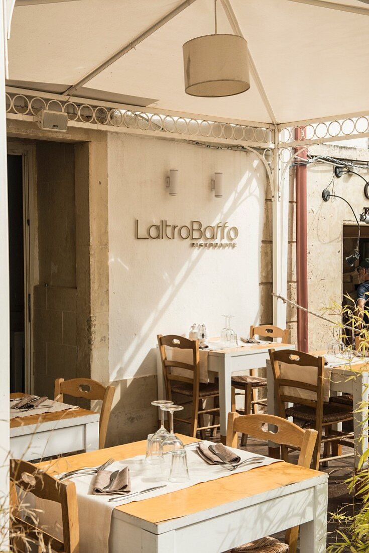 Tables laid on the terrace of the Laltro Baffo Restaurant in Otranto, Italy