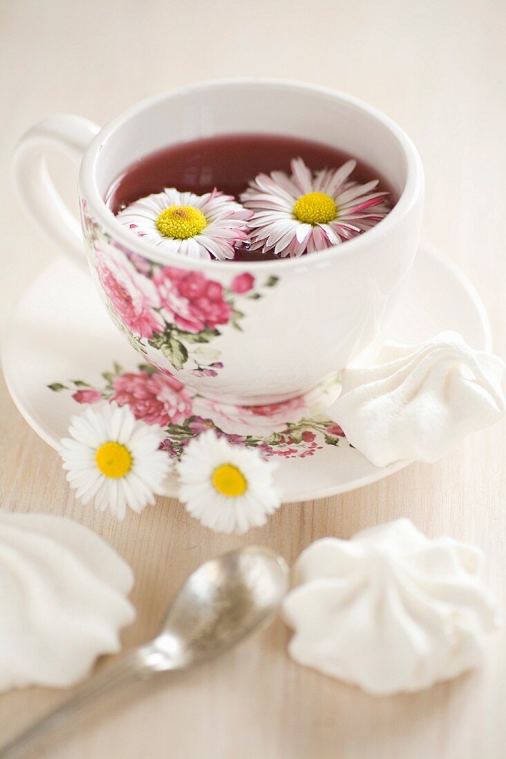 Daisies floating in tea in floral teacup