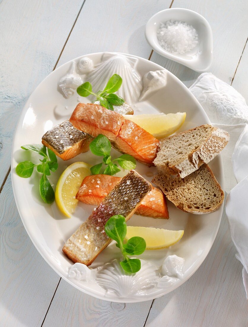 Smoked salmon with lemon wedges and bread