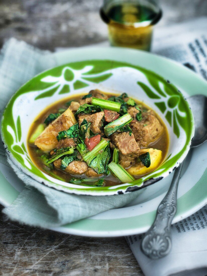 Indian pork curry with leafy greens and lemon