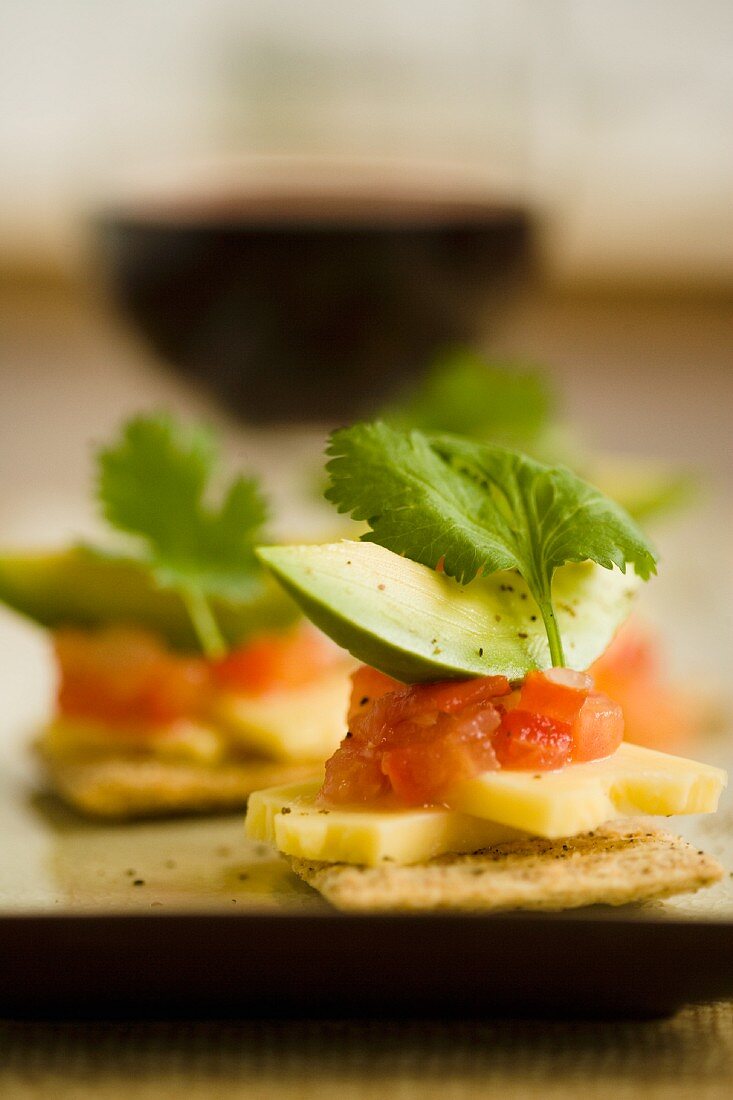 Crackers cheese, tomatoes and avocado served with red wine