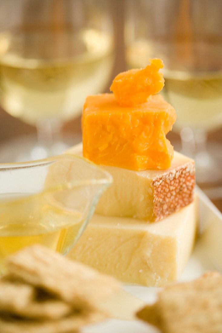 Käseplatte mit Honig und Crackers zum Weißwein