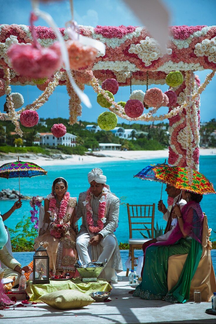 Luxuriant floral decorations for Indian beach wedding beneath a blue sky