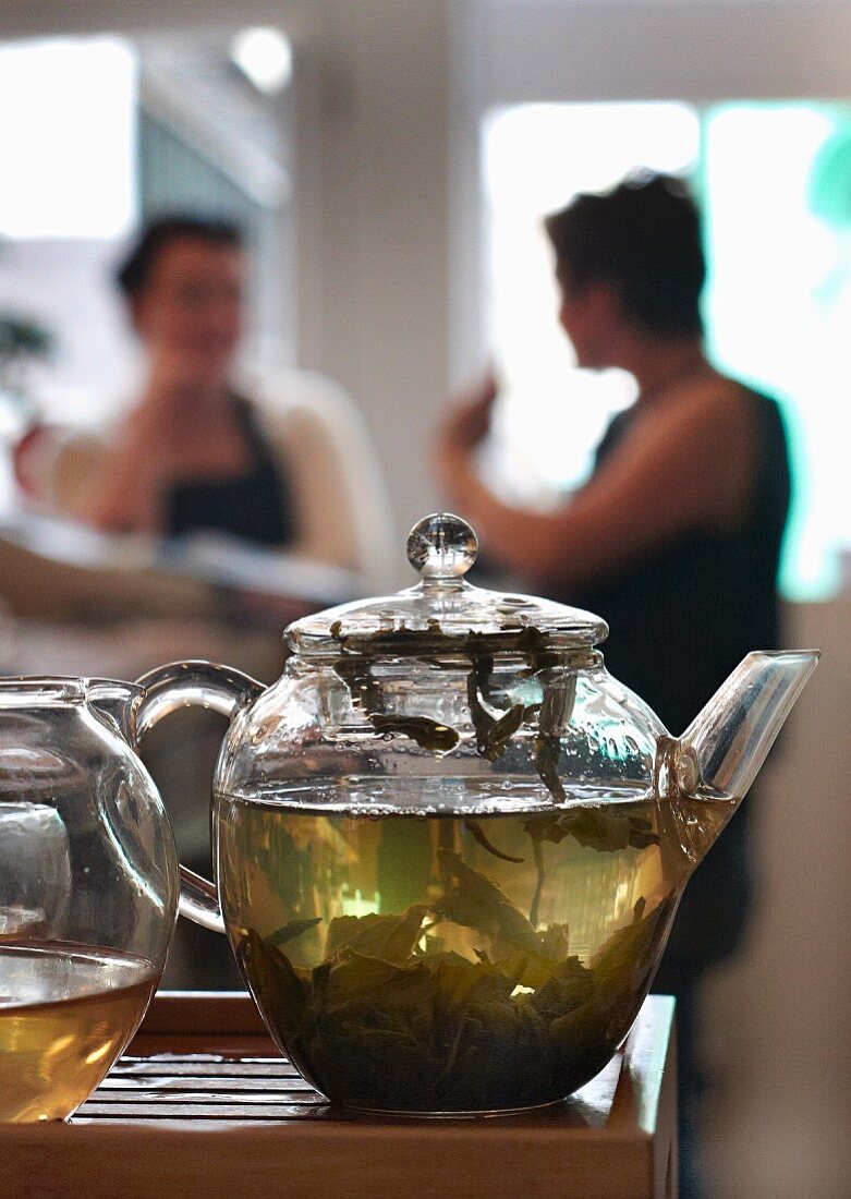 Glasteekanne mit grünem Tee im Restaurant