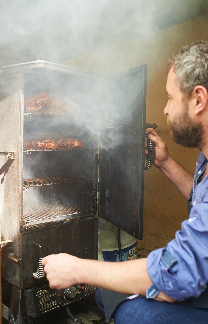 A chef grilling beef briskets in a smoker