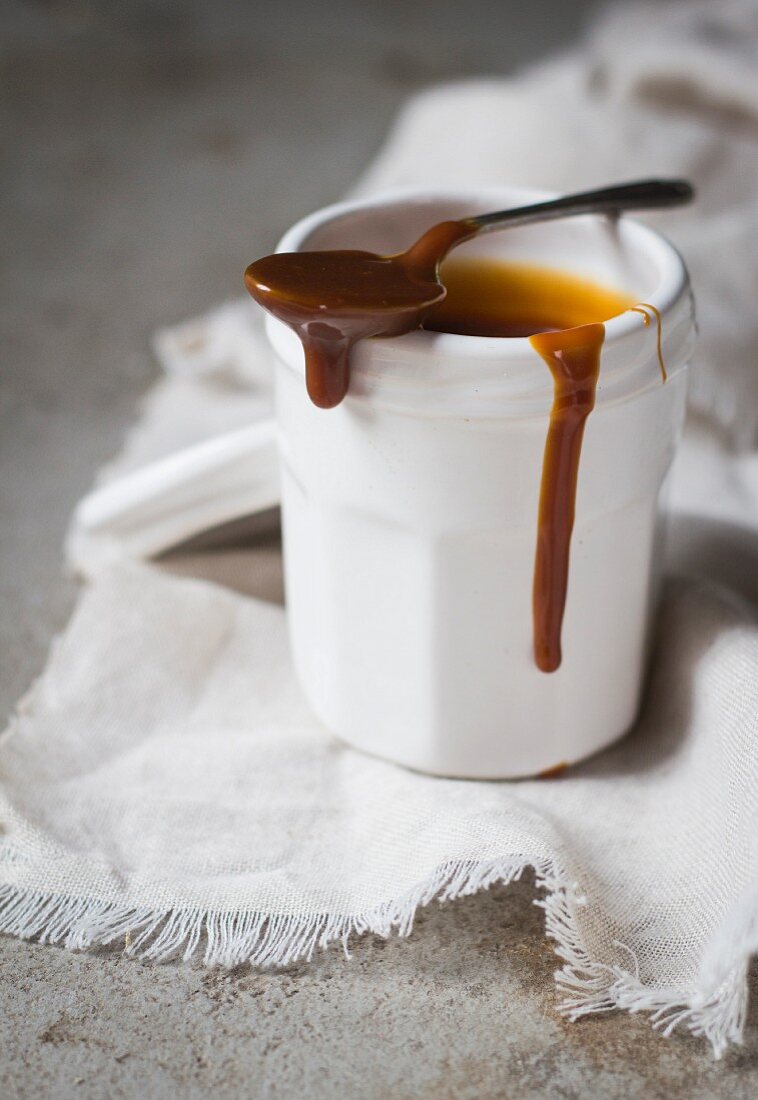 Salted caramel sauce in a cot with a spoon