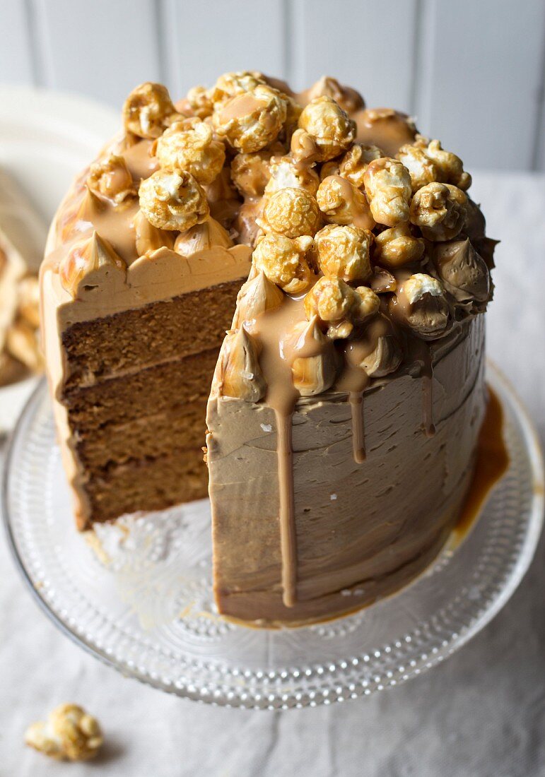Salted caramel cake topped with popcorn, sliced