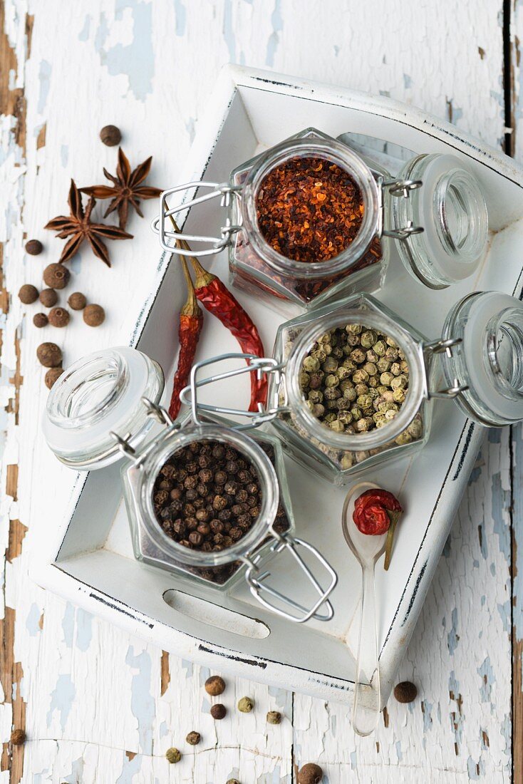 Various spices in storage jars on a tray