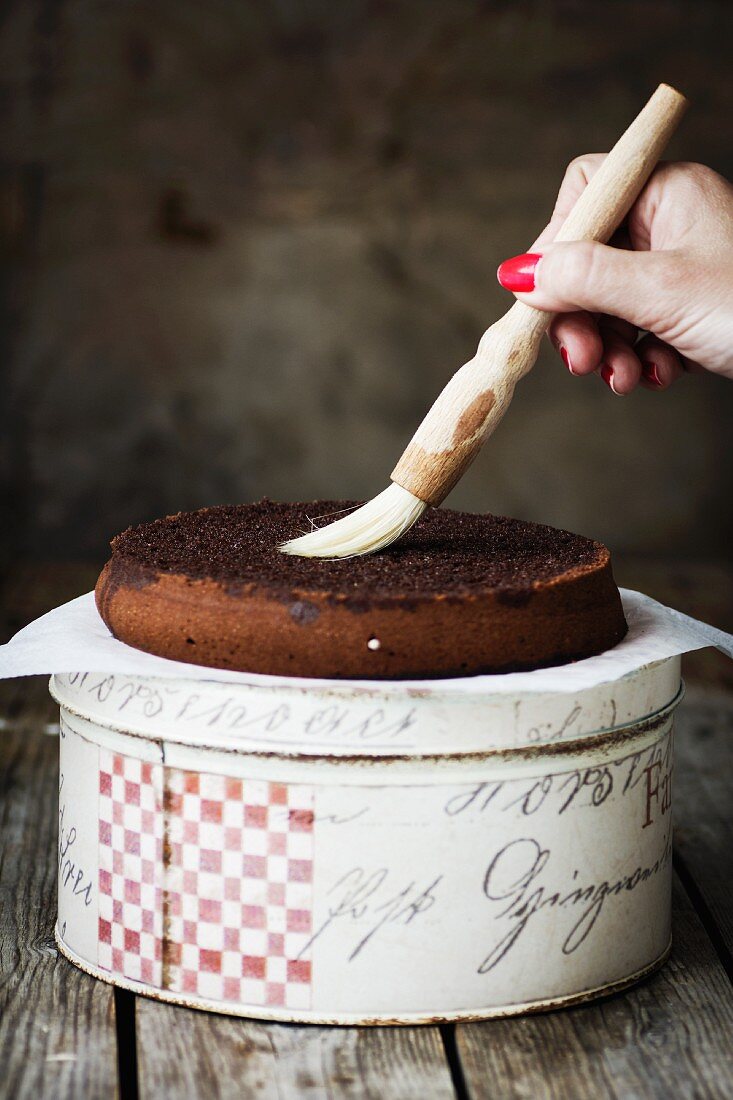 A cake base being brushed