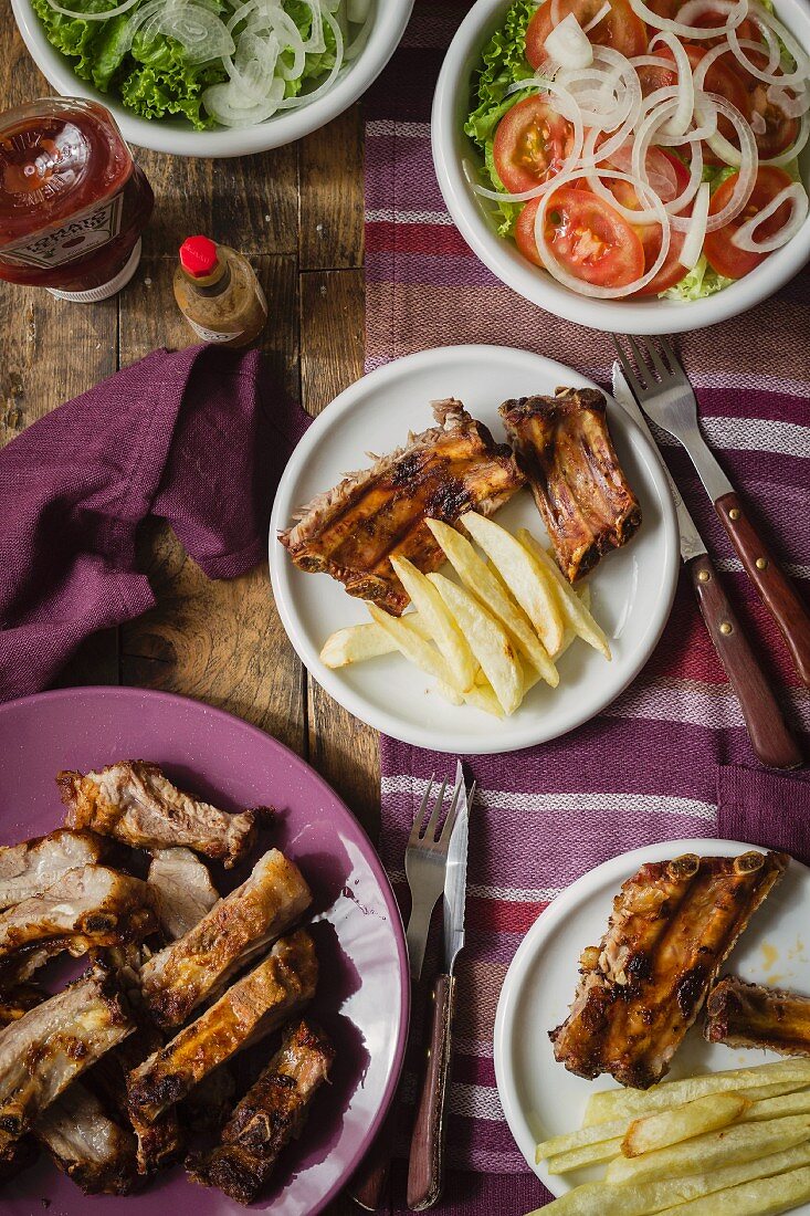 Schweinerippchen mit Pommes frites und Salat (Draufsicht)