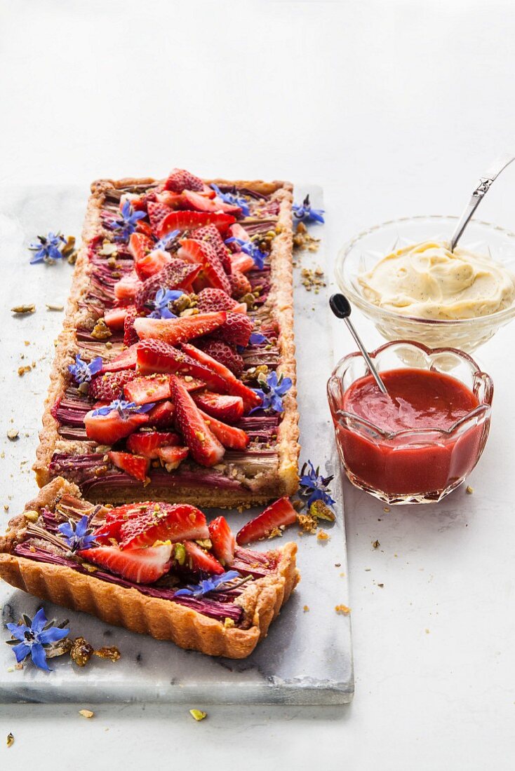 Rhubarb tart with fresh strawberries, borage flowers, mascarpone and strawberry and rhubarb coulis