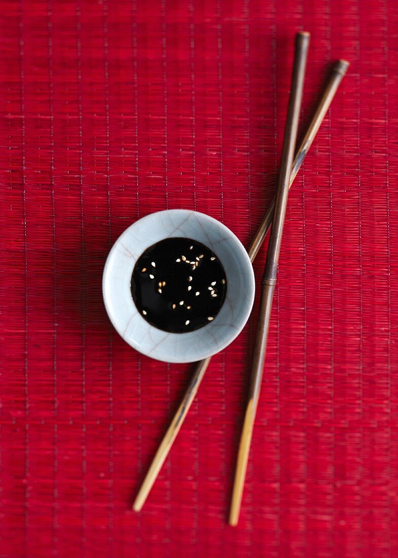 Soy sauce with sesame seeds and chopsticks (China)