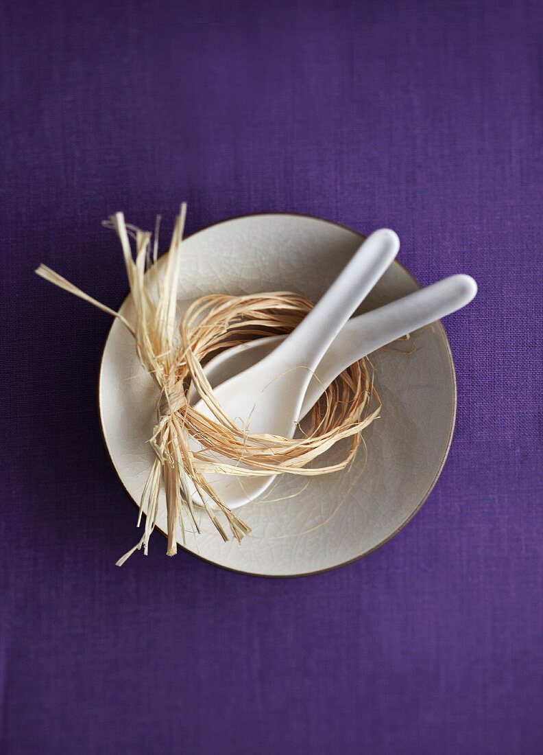 A soup bowl with raffia ribbons and spoons from China