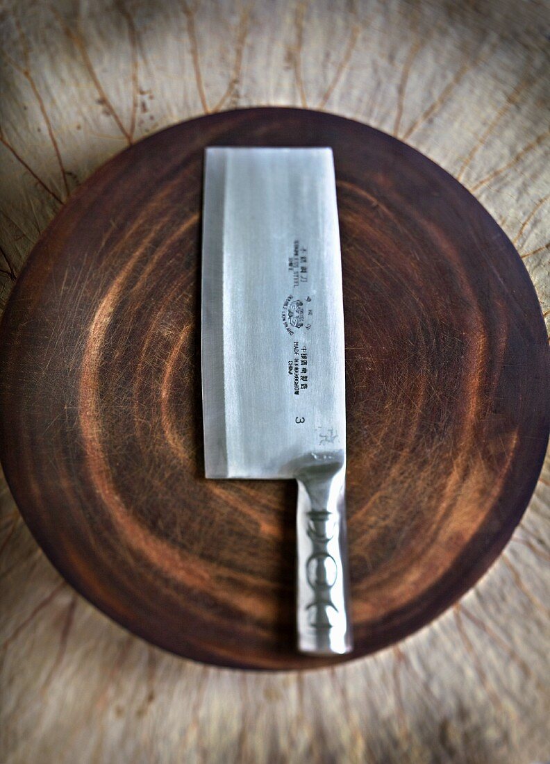 A meat cleaver on a wooden plate (China)