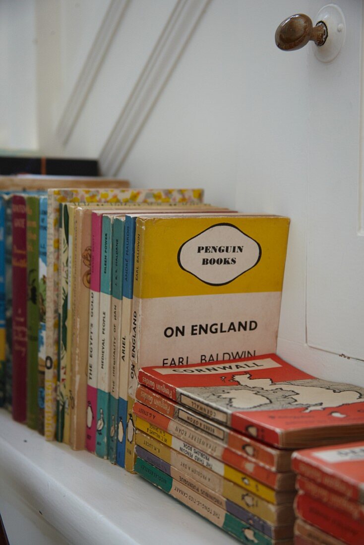 Vintage English books arranged stood and stacked on bookshelf