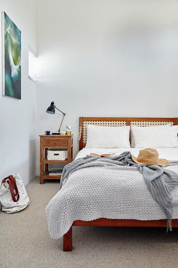 Double bed with headboard and vintage bedside table in bedroom