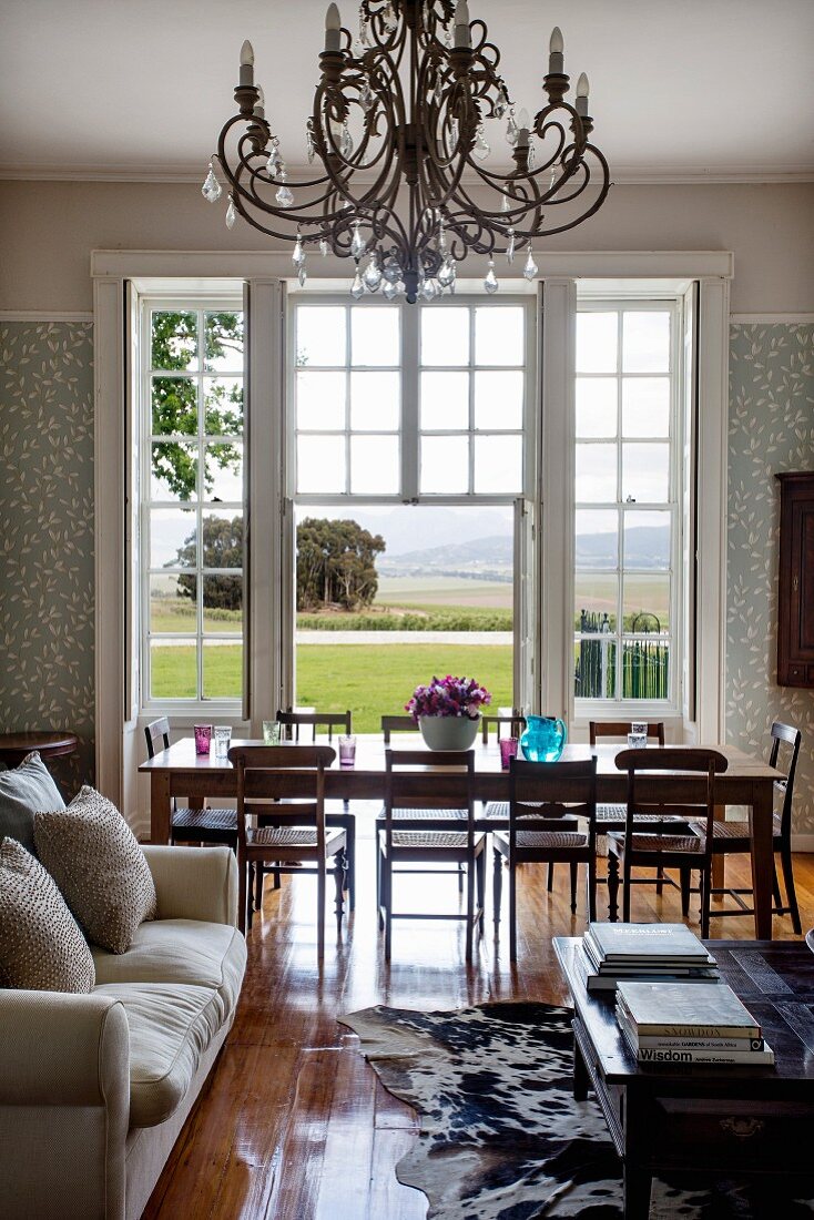 Sofa und Couchtisch vor Essplatz in elegantem Ambiente am Fenster mit Landschaftsblick