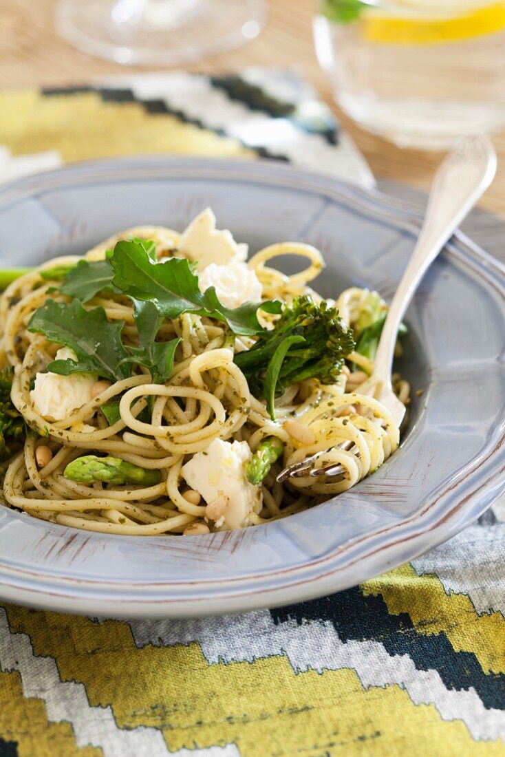 Spaghetti with herb pesto, broccoli, green asparagus, feta cheese and rocket