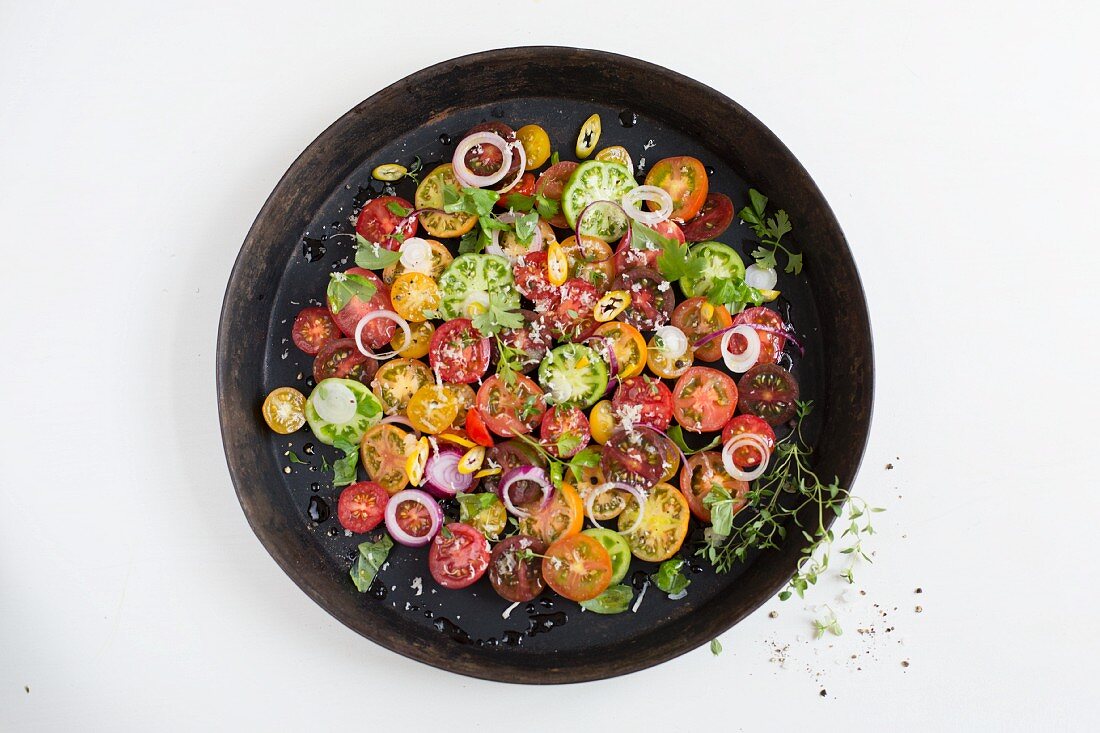 An heirloom tomato salad with onion rings and herbs