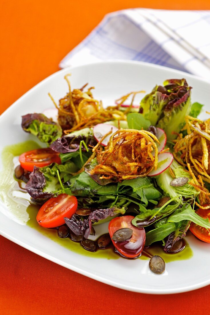 Crispy chicken nuggets on a bed of salad with a seed oil dressing