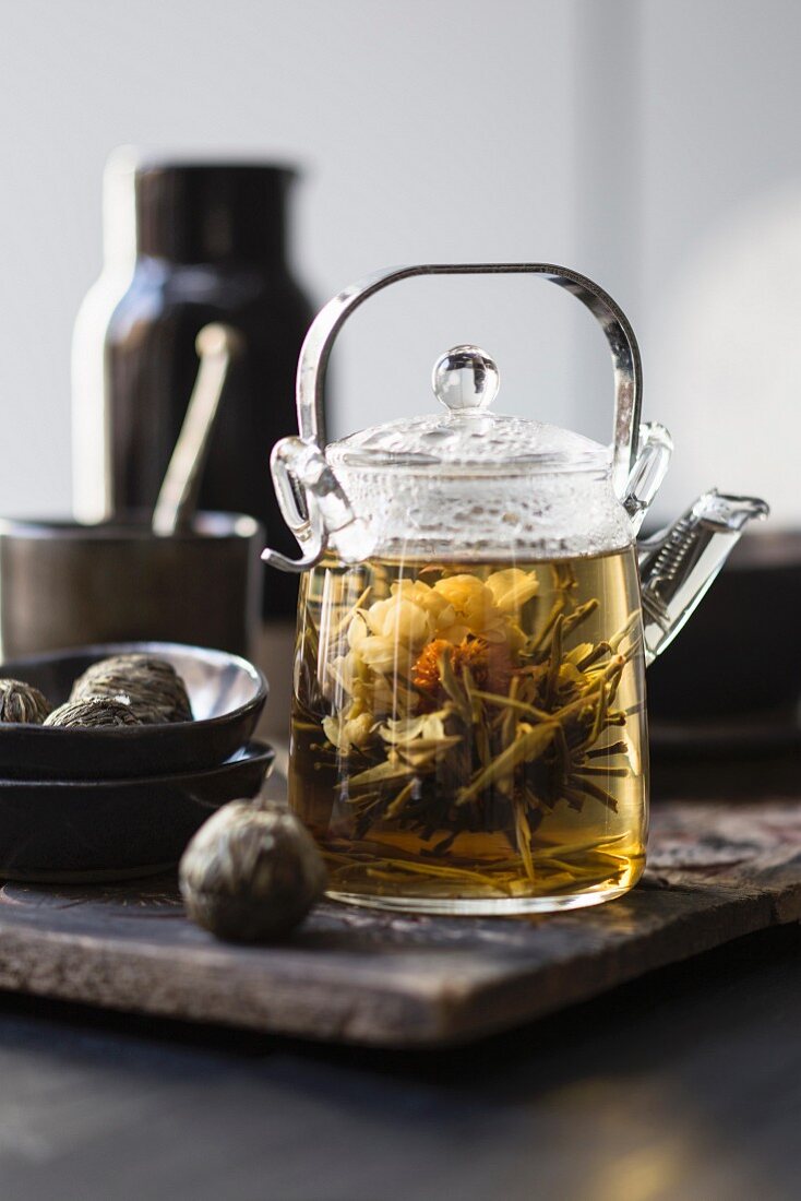 White tea in a glass teapot with a tea flower