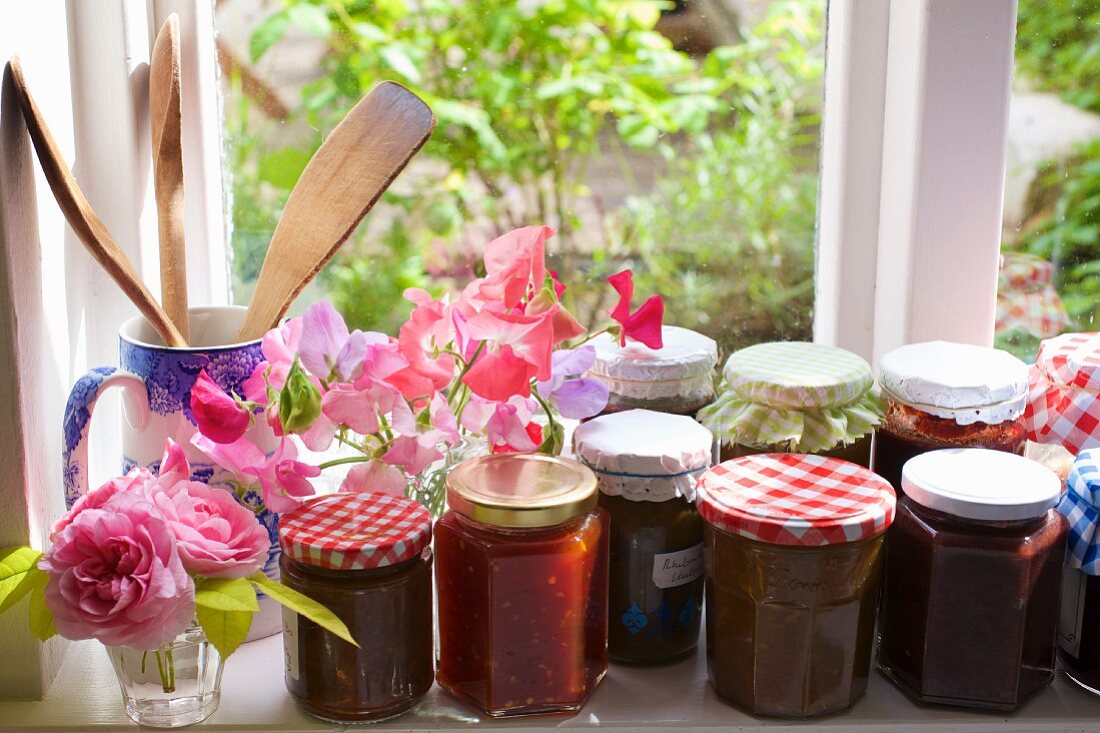 Various jars of jam on a windowsill
