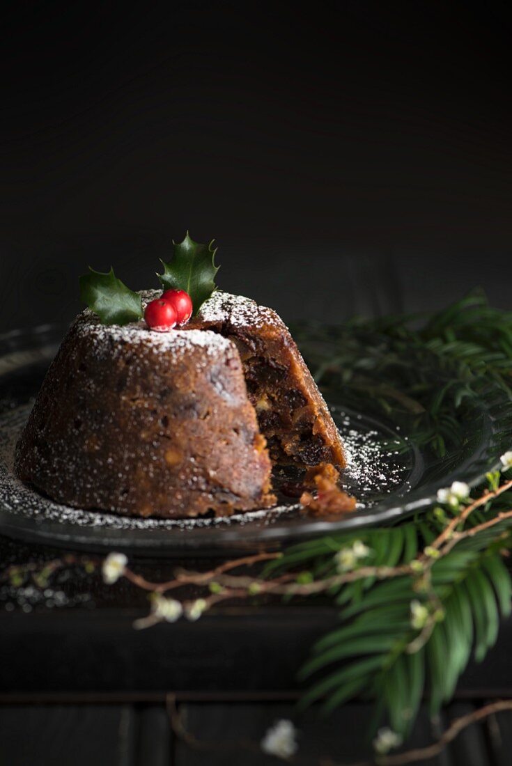 Christmas pudding decorated with holly, sliced