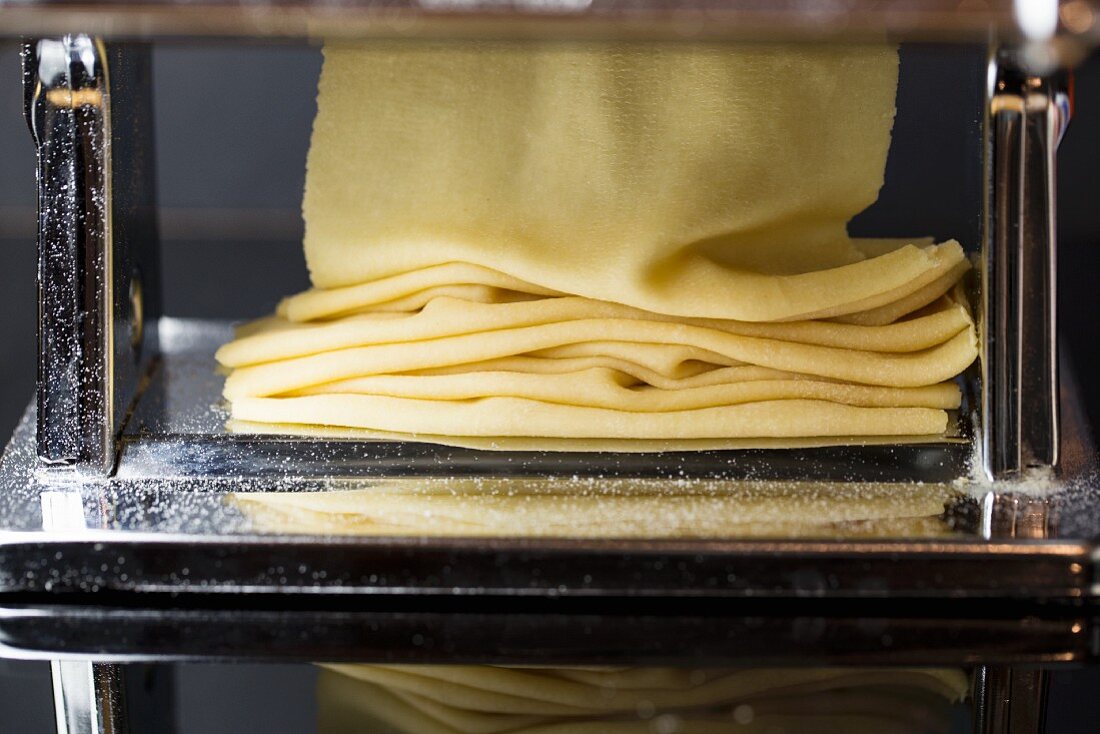 Fresh pasta dough being passed through a pasta machine