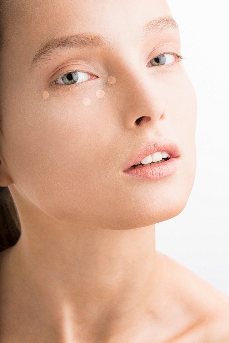 Junge Frau mit einigen Tupfern Concealer unter dem Auge