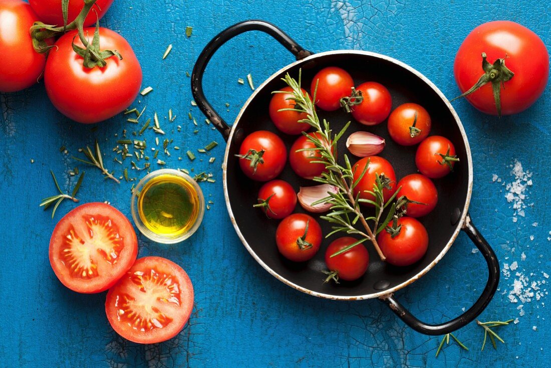 ingredients for pasta sauce: cherry tomatoes, rosemary, garlic and olive oil