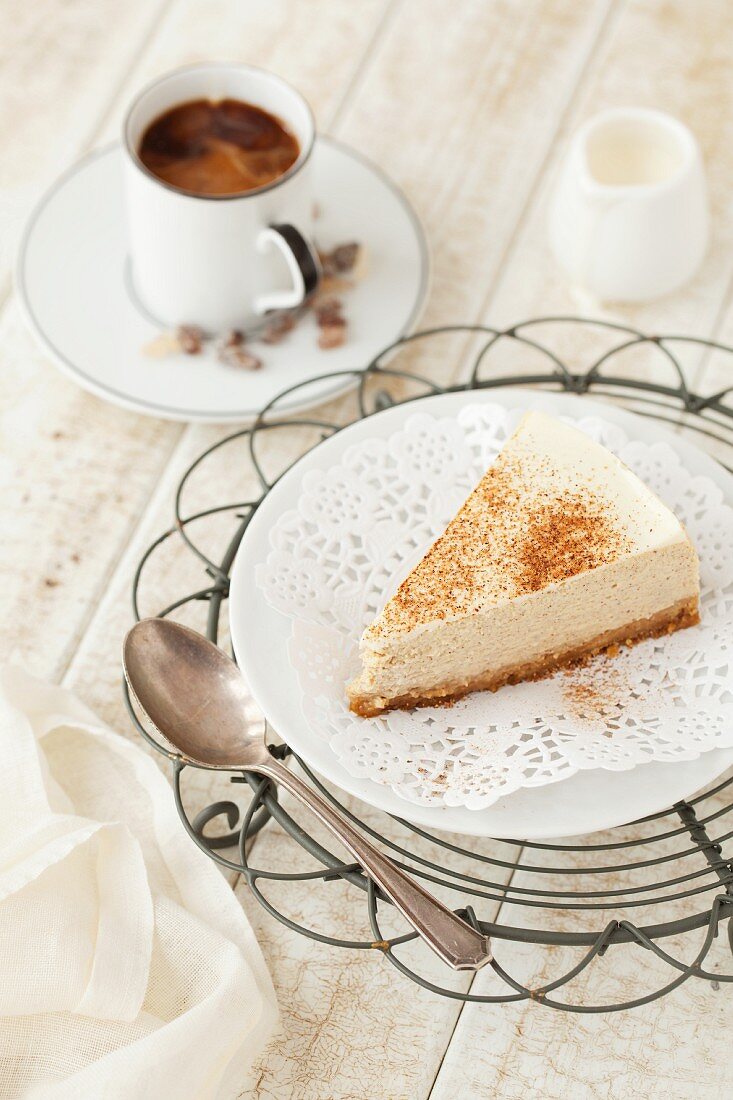 Ein Stück Käsekuchen mit Gewürzen und Kaffee