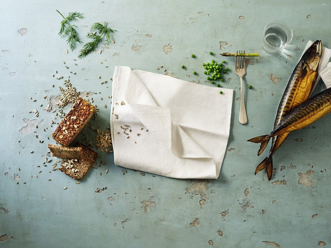 an arrangement of smoked mackerel, wholemeal bread and a white napkin