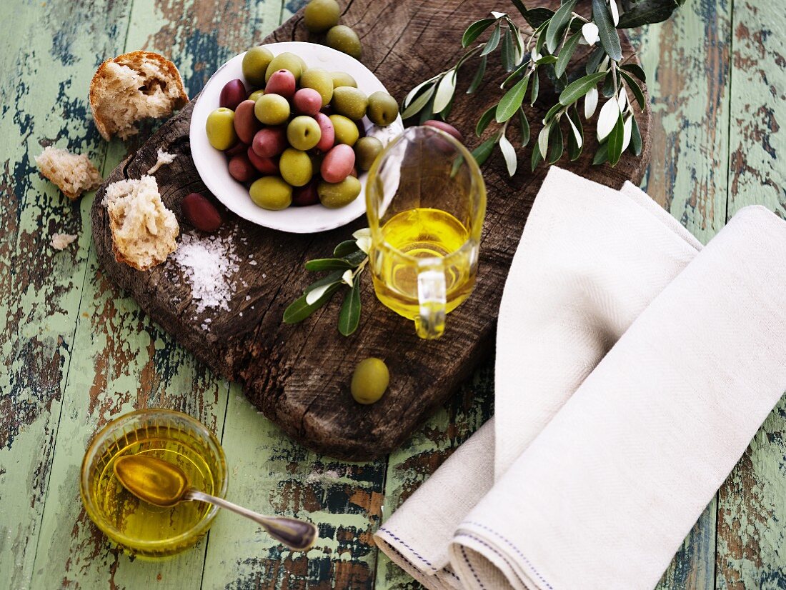 Ölstilleben mit Olivenöl, Oliven, Brot und Salz