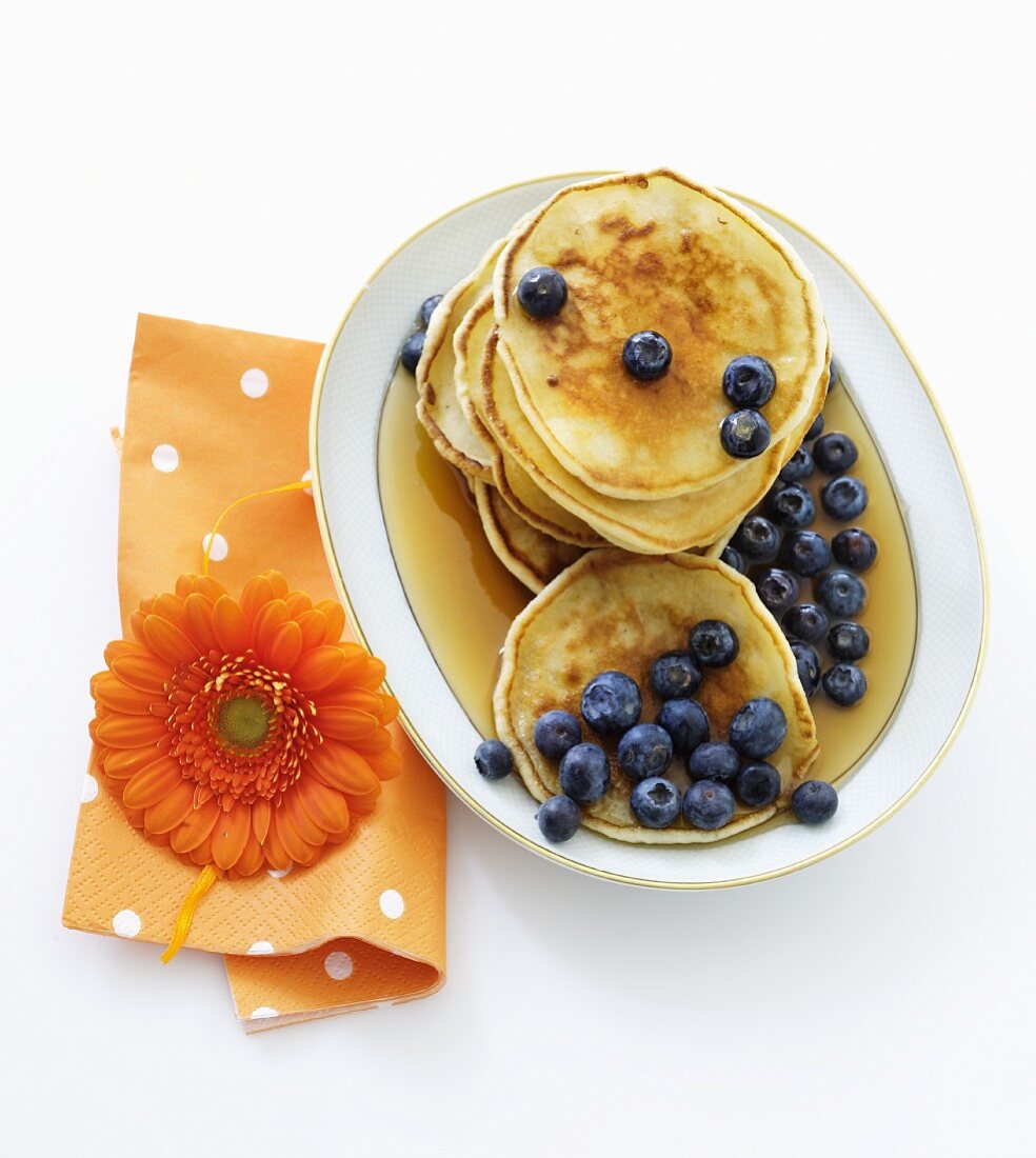 Mini pancakes with blueberries and maple syrup