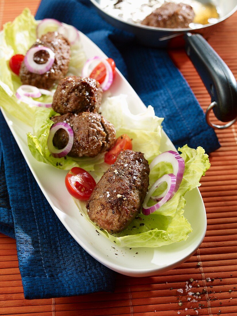 Cevapcici mit Zwiebeln, Tomaten und Salat