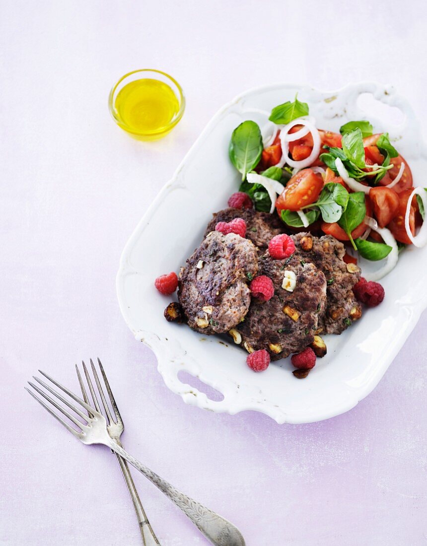 Beef with nuts, olives, raspberries and tomato salad