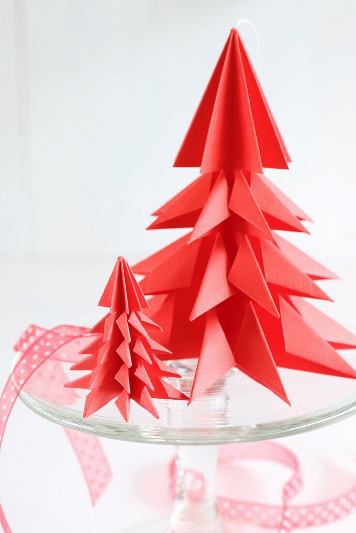 Red origami Christmas trees on glass cake stand