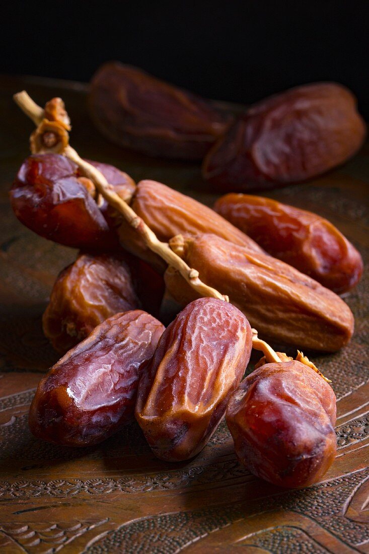 Dates with a sprig on a wooden platter