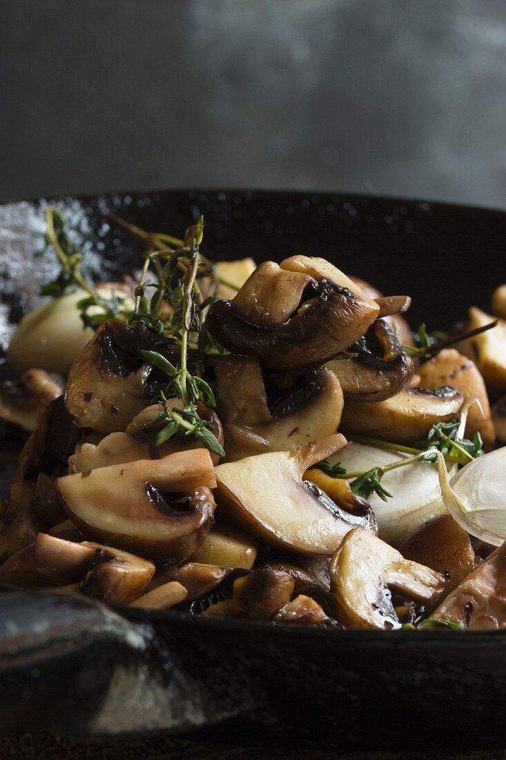 Fried mushrooms with thyme in a cast iron pan