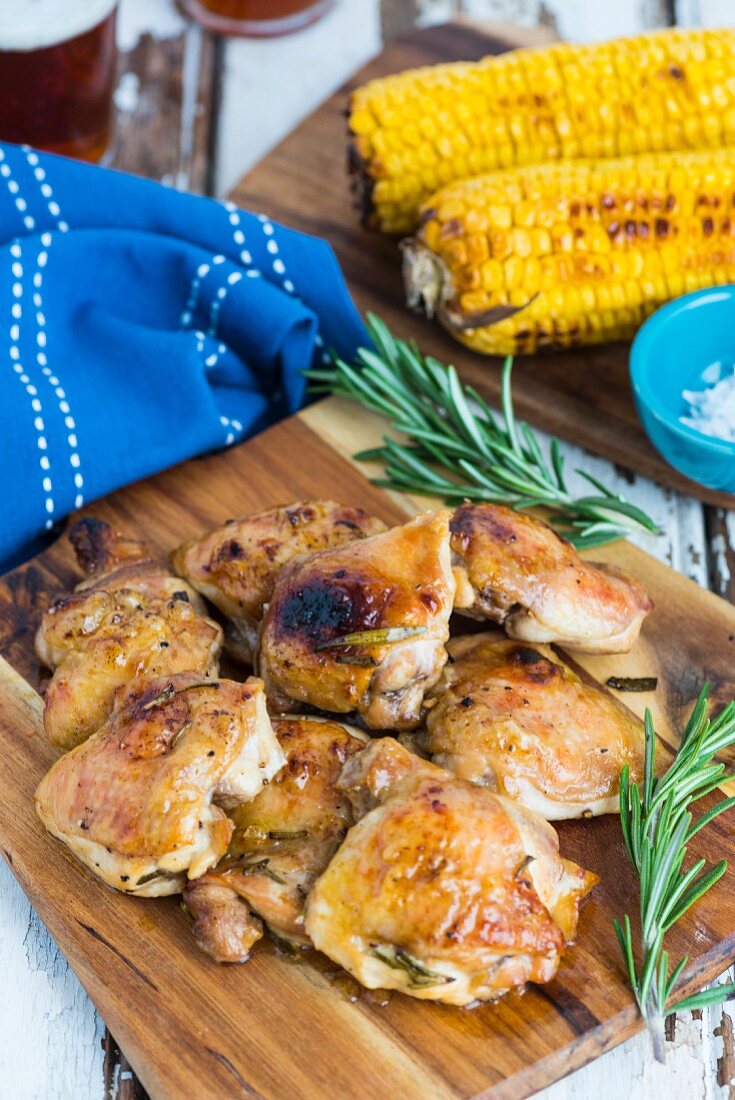 Gegrillte Hähnchenkeulen und Maiskolben mit Rosmarin