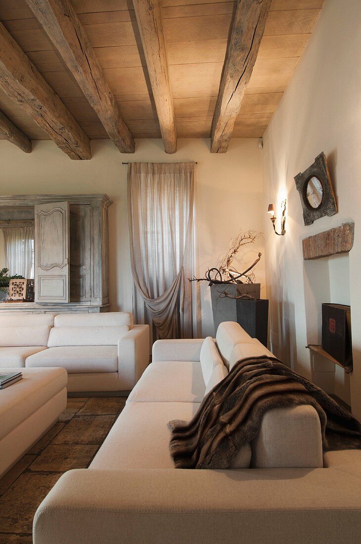 Elegant white sofa set in living room with wood-beamed ceiling