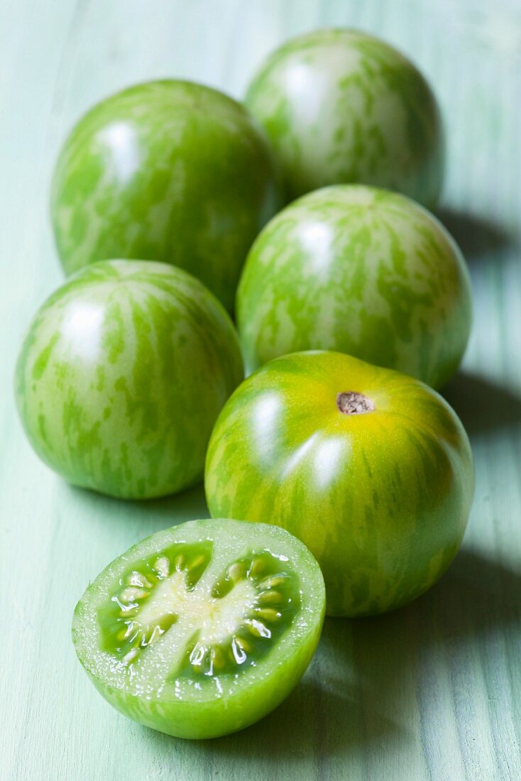 Mehrere grüne Tomaten, ganz und halbiert