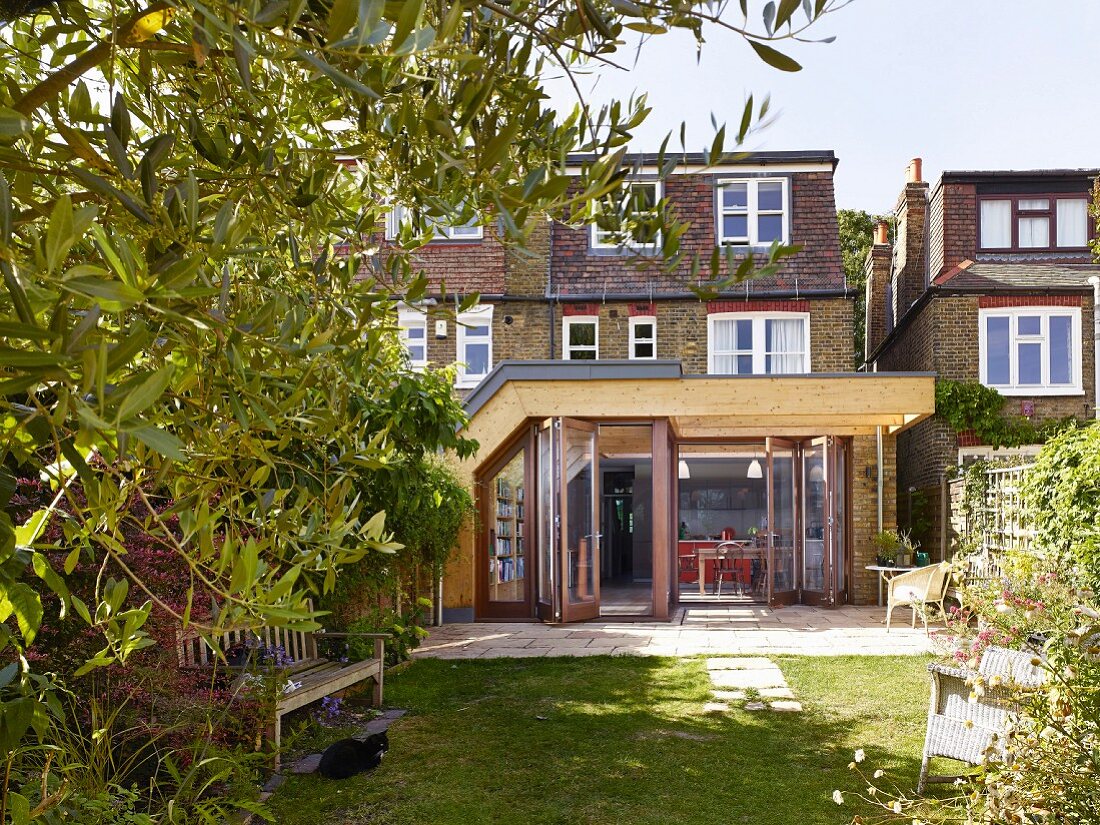 View from garden towards brick house with modern wood and glass extension