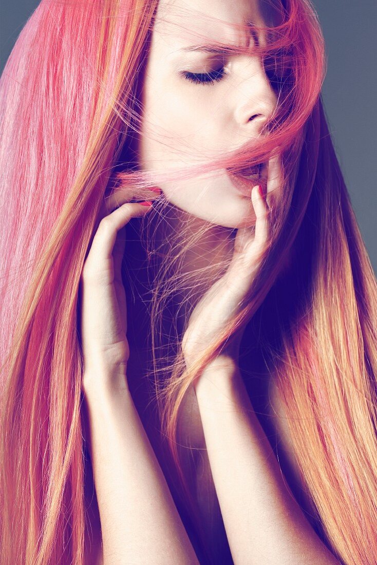 Junge Frau mit langen Haaren in Pink-Orange