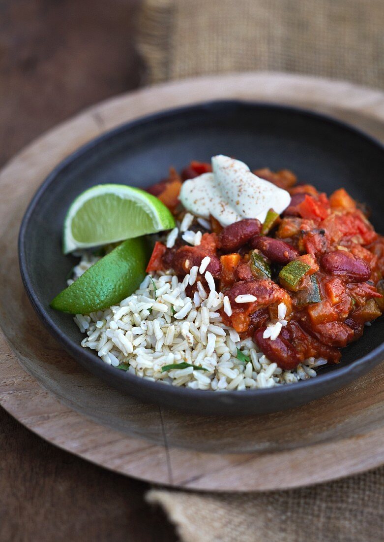 Mexican bean chili with rice, sour cream and lime